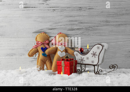 Felt  dolls with Santa sleds, candles and toys in a snow over wooden background, still life Stock Photo