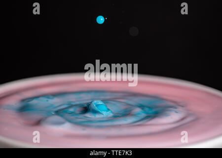 Splash of milk droplets in close up macro high resolution isolated against a black background Stock Photo