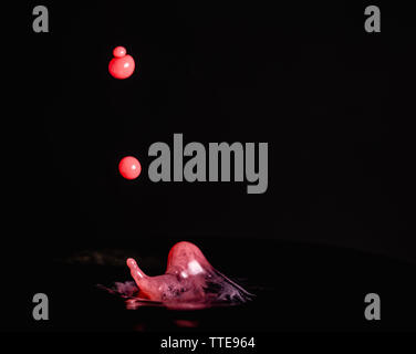 Splash of milk droplets in close up macro high resolution isolated against a black background Stock Photo