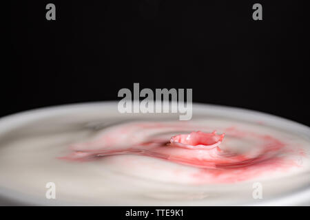 Splash of milk droplets in close up macro high resolution isolated against a black background Stock Photo