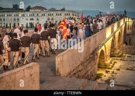 SKOPJE,MACEDONIA-AUGUST 28,2018: entrants of the International Music & Folk-Dance Festival or Skopje Fest cross the stone bridge in a  procession. Stock Photo