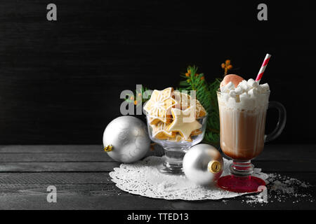 Cup of coffee with whipped cream and sweets on black table Stock Photo