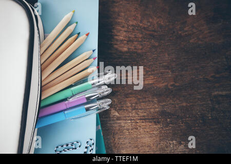 Pencil case with various stationery on old  wooden table Stock Photo