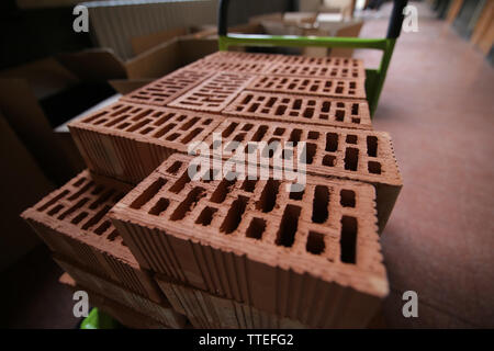 Details of a pile of stacked clay bricks with holes. Stock Photo