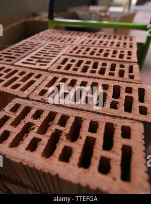 Details of a pile of stacked clay bricks with holes. Stock Photo