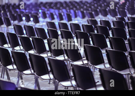 Rows of empty plastic seats in an empty conference room - no people. Stock Photo