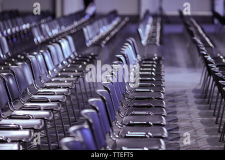 Rows of empty plastic seats in an empty conference room - no people. Stock Photo