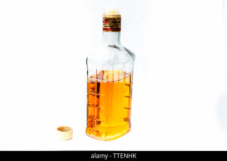 Scotch or whisky or whiskey bottle isolated on white with half filled in it,Close up view along with top shot. Stock Photo