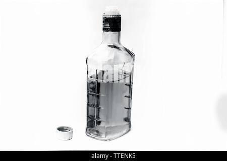 Scotch or whisky or whiskey bottle isolated on white with half filled in it,Close up view along with top shot. Stock Photo