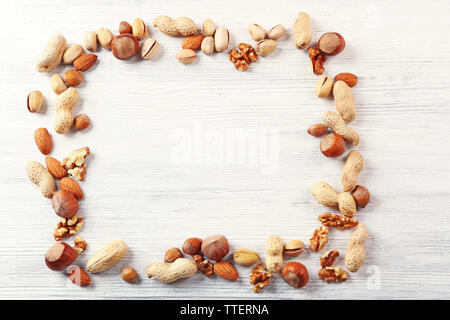 Frame made with mix of nuts on the white wooden table Stock Photo