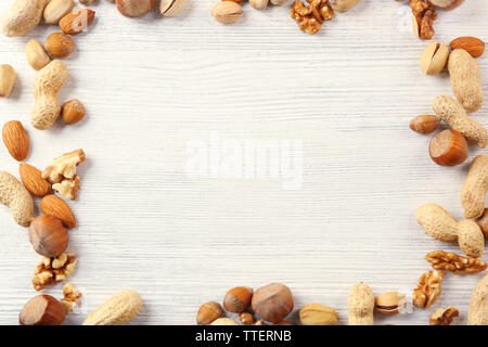 Frame made with mix of nuts on the white wooden table Stock Photo