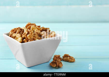 Walnuts in the bowl on blue wooden background Stock Photo