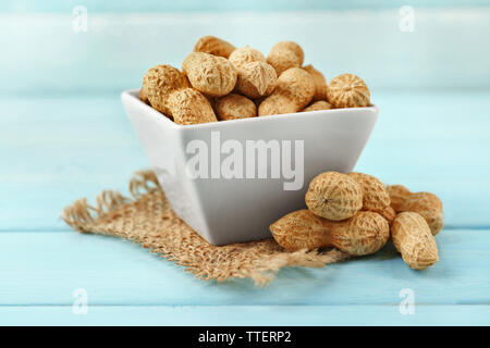 Peanuts in the bowl on blue wooden background Stock Photo