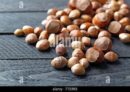 Scattered hazelnuts and acorns on grey wooden table Stock Photo