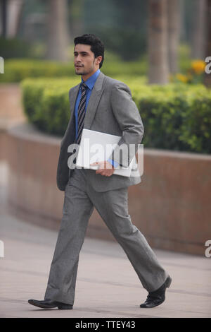 Businessman carrying a laptop Stock Photo