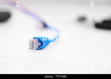 Connector of blue Ethernet cable on blurred white background Stock Photo
