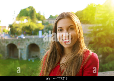 Portrait of smiling young woman with sunlight flare and copy space Stock Photo