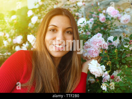 Close up of beautiful natural woman in the garden between roses Stock Photo