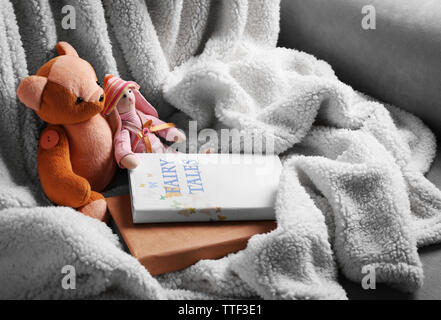 Rag toys with fairy tales books on bedspread. Childhood concept Stock Photo