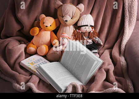 Rag toys with fairy tales books  on bedspread. Childhood concept Stock Photo