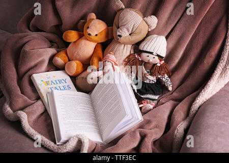 Rag toys with fairy tales books  on bedspread. Childhood concept Stock Photo