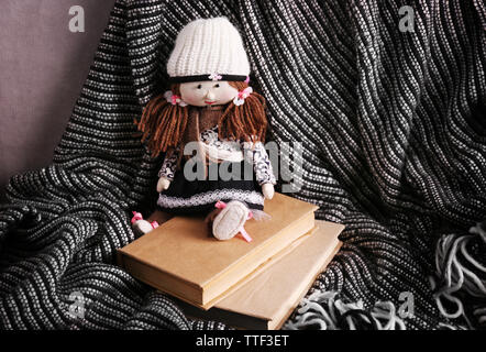 Rag doll with fairy tales books on bedspread. Childhood concept Stock Photo