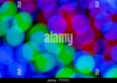 Blurry multicolored garland with glowing lights. Christmas, new year, birthday and wedding concept . Blurred background, bright colored light bulbs, l Stock Photo