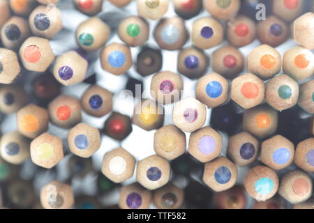 colored pencils stacked. random rainbow color pattern pencils close up shot with back light. random pattern colors placement. Stock Photo