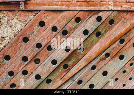 Grunge, wooden, ancient texture. Old background with wavy paint, orange paint and round holes Stock Photo