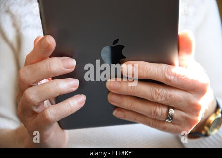 Close up of a senior woman holding an Apple mini  iPad. Stock Photo