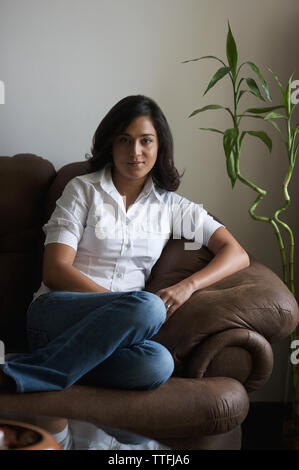 Portrait of a woman sitting on a couch Stock Photo