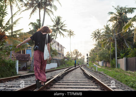 Caucasian girl walking on train tracks Sri Lanka Stock Photo