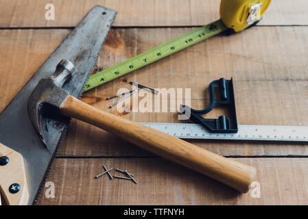 Close up of carpentry tools scattered on a wooden table. Stock Photo