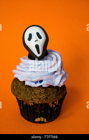 funny halloween monster mask cupcake on an orange background Stock Photo