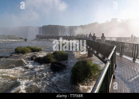 Beautiful landscape of tourists on footbridge visiting big waterfalls