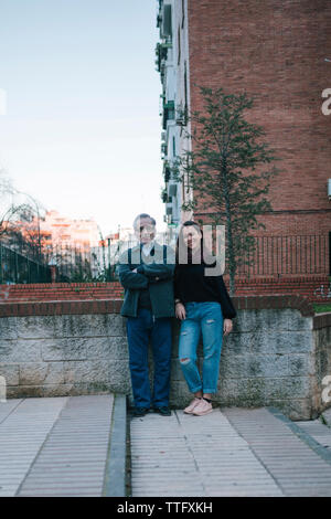 Father and daughter of adult age smile on the street