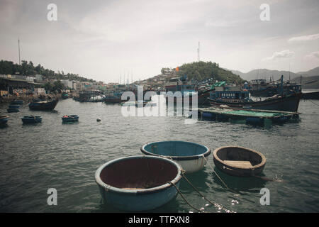 Boats moored in sea at harbor against sky Stock Photo