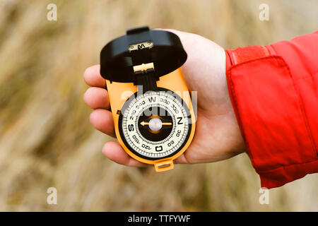 Hand of a woman in the outdoors using a compass to navigate Stock Photo