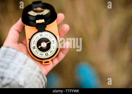Hand of a woman in the outdoors using a compass to navigate Stock Photo