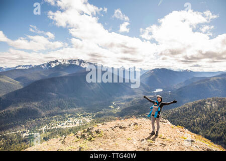Active mother stands on the summit of the Cascade Lookout with baby