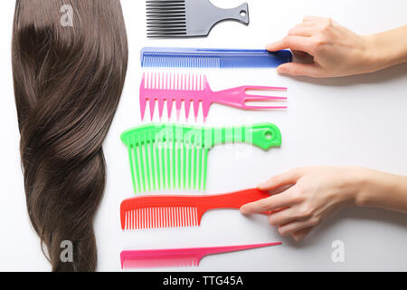 Barber set with female hands, strand of hair and different combs, isolated on white Stock Photo