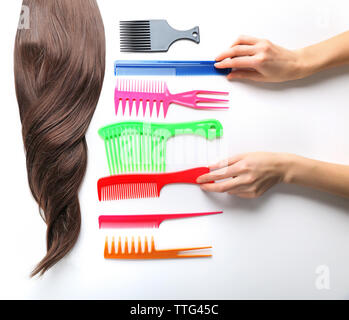 Barber set with female hands, strand of hair and different combs, isolated on white Stock Photo