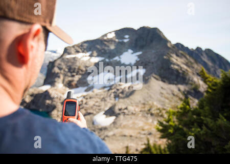 Mountaineer navigates using a GPS device. Stock Photo
