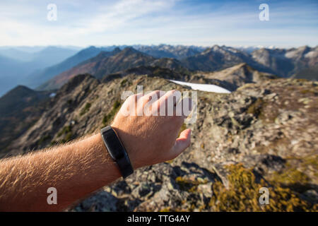 Trail runner checks his fitness watch while on a mountain ridge. Stock Photo