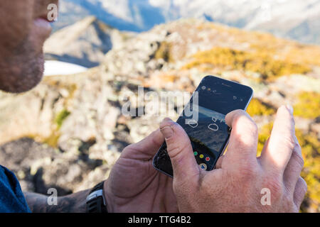 Climber sending map and instructions to Search and rescue team Stock Photo