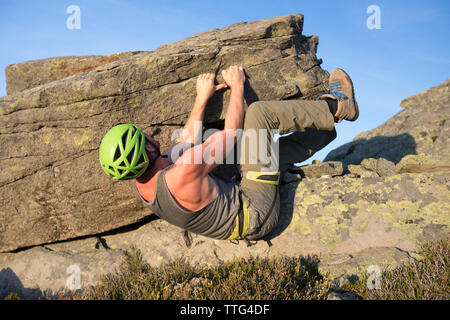 Low angle of man bouldering on rock in the Coast Mountain Range. Stock Photo