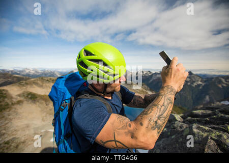 Mountaineer takes photo with his smartphone. Stock Photo