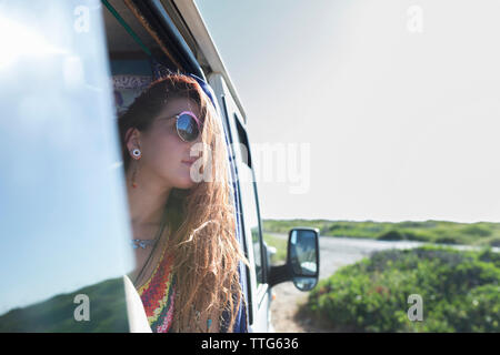 Woman looking through window while sitting in motor home Stock Photo