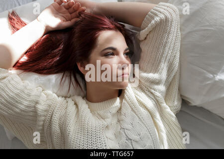 High angle view of thoughtful woman lying on bed at home Stock Photo