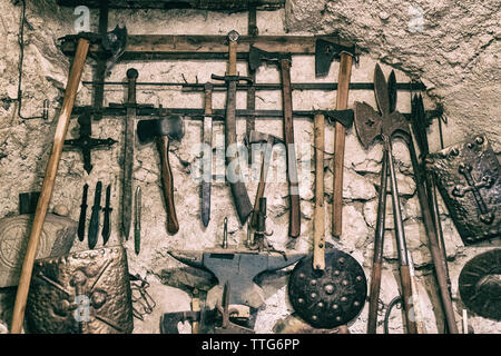 Close-up of various ancient tools hanged on old wall Stock Photo